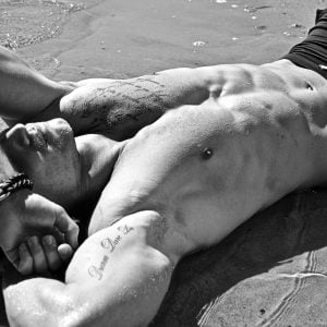 Man resting on the beach, uncovering the truth about push-up men's swimwear