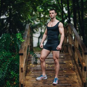 Man wearing ZLCOPENHAGEN black wrestling singlet in forest setting – athletic gymwear