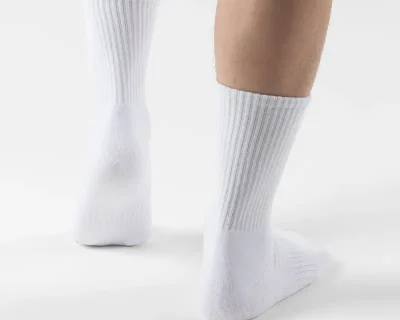 Man showcasing the sleek design and comfort of WHITE NORDIC BREEZE SHORT CREW SOCKS