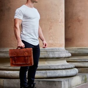ZLC Man standing with his bag, showcasing the muscle-fit design of our tailored white T-shirt for men that enhances his build.