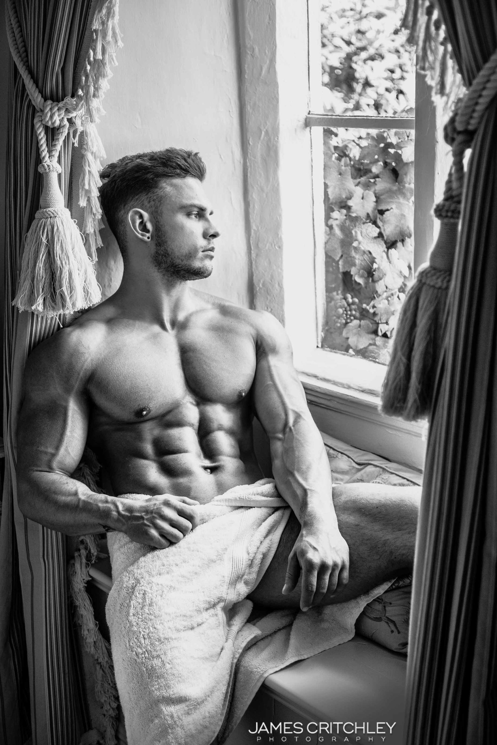 Lækker mand slapper af efter træning, udstråler velbehag og styrke fra en sund muskel krop.