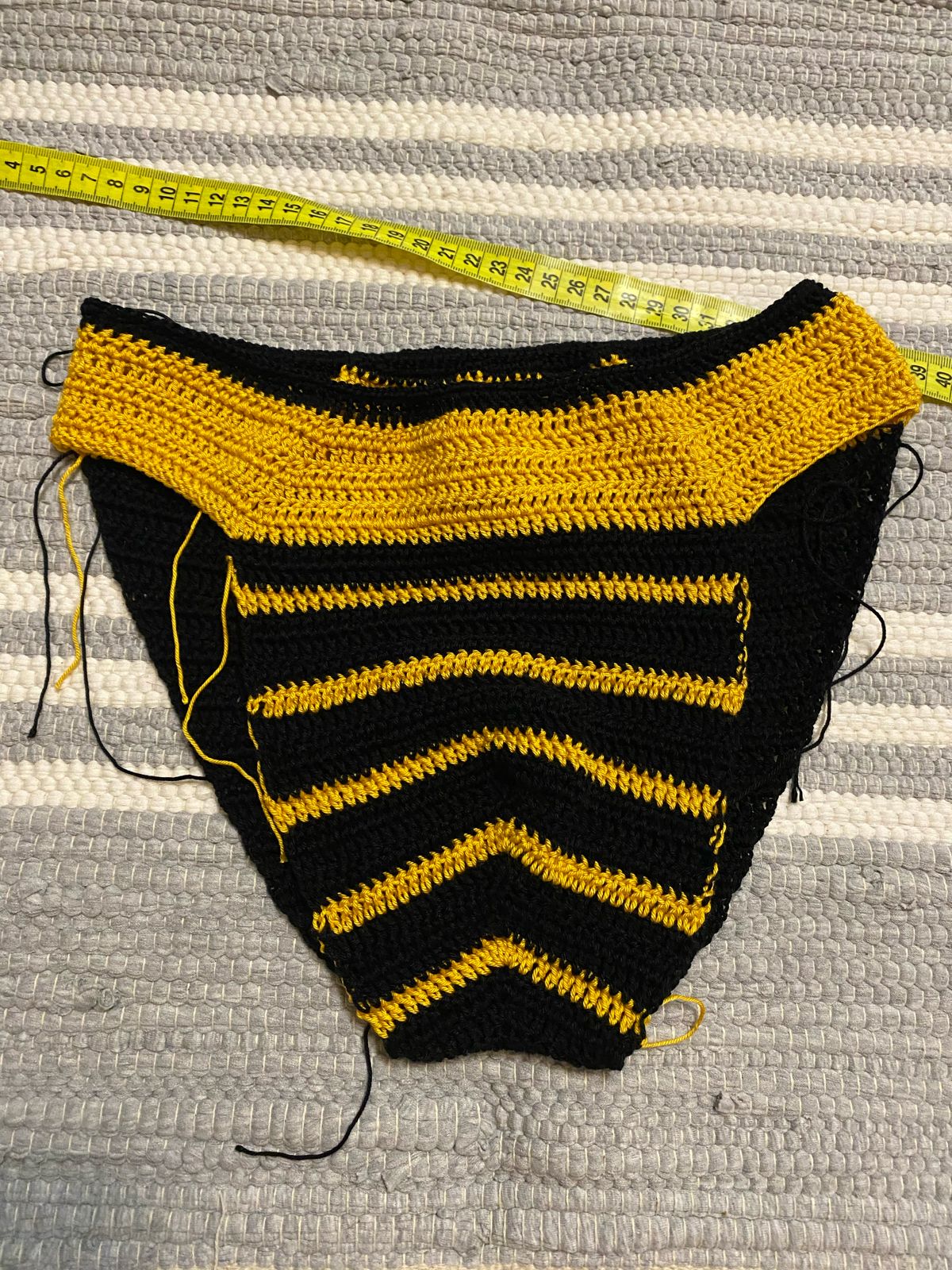 Image showing the meticulous process of crafting crocheted swimwear for men, with a focus on a designer's hands as they skillfully crochet the fabric, highlighting the detailed stitches and the quality of the yarn used.