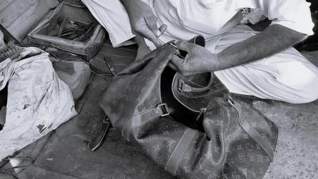 Craftsman repairing vintage Louis Vuitton bag in Lahore, Pakistan – black and white
