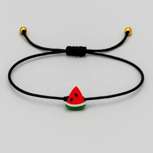 Free Palestine watermelon charm bracelet on a slim black cord by ZLCOPENHAGEN on a light grey background